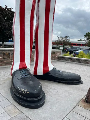 Close-up of Uncle Sam statue's black shoes and red-white striped pants